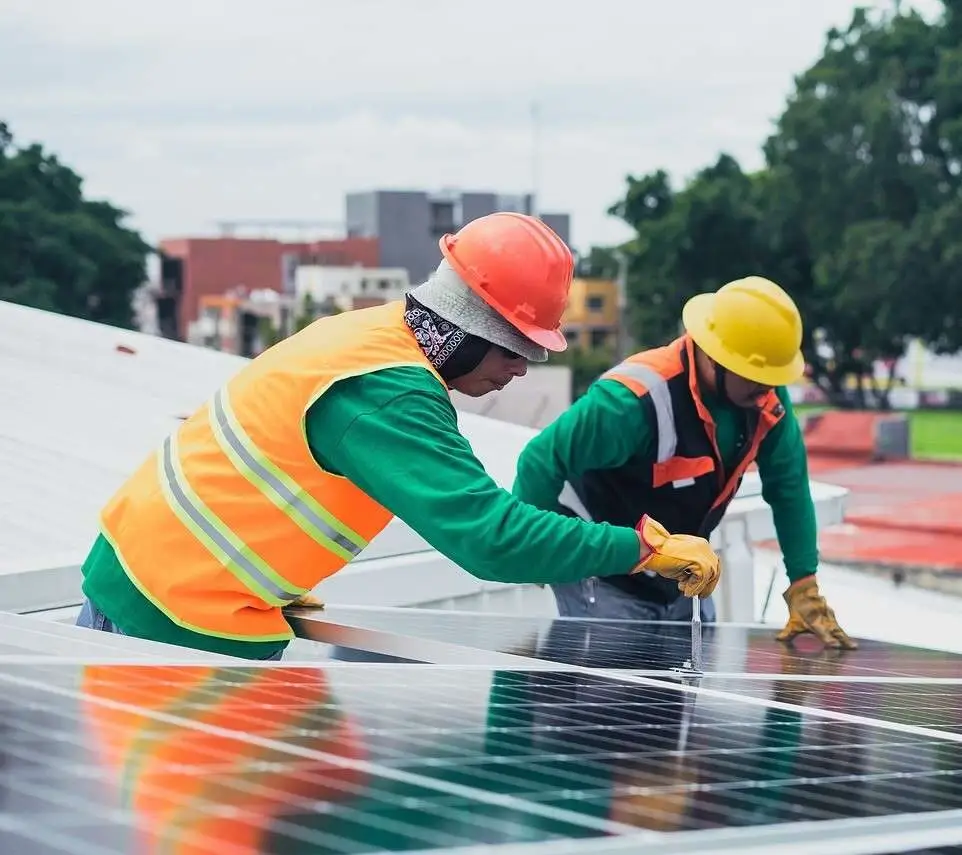 Technicians maintaining large commercial solar power plant